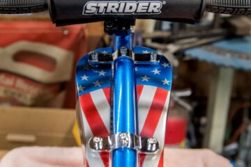 A dummy gas tank hangs from the frame of the customized Tiny Strider bicycle designed by famed motorcycle customizer Carl Pusser and his nine-year-old granddaughter Jocelyn Dunn.